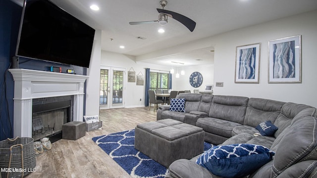 living area with baseboards, ceiling fan, recessed lighting, a fireplace, and wood finished floors