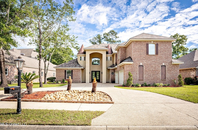 view of front of house with driveway, a front yard, brick siding, and a garage