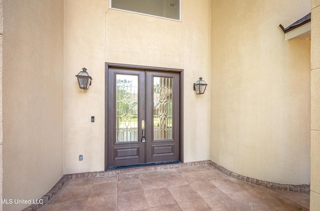 property entrance featuring french doors and stucco siding