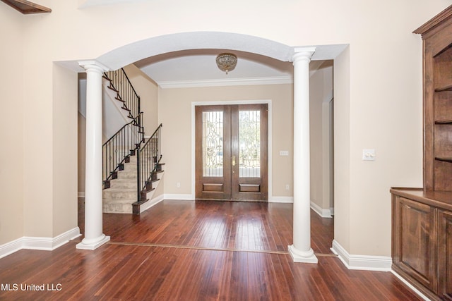 foyer entrance featuring french doors, hardwood / wood-style flooring, stairs, baseboards, and ornamental molding