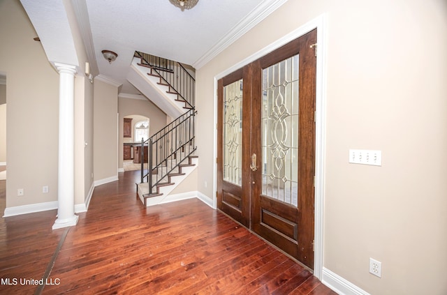entryway featuring french doors, wood-type flooring, decorative columns, stairway, and crown molding