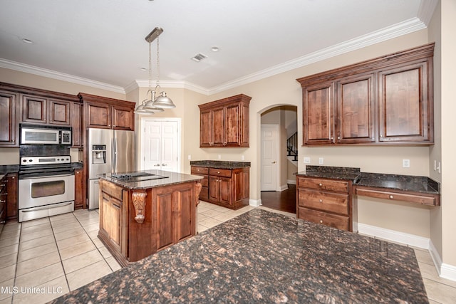 kitchen featuring stainless steel appliances, light tile patterned floors, ornamental molding, arched walkways, and dark stone counters