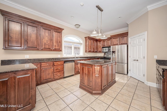 kitchen with appliances with stainless steel finishes, light tile patterned flooring, crown molding, a center island, and decorative light fixtures