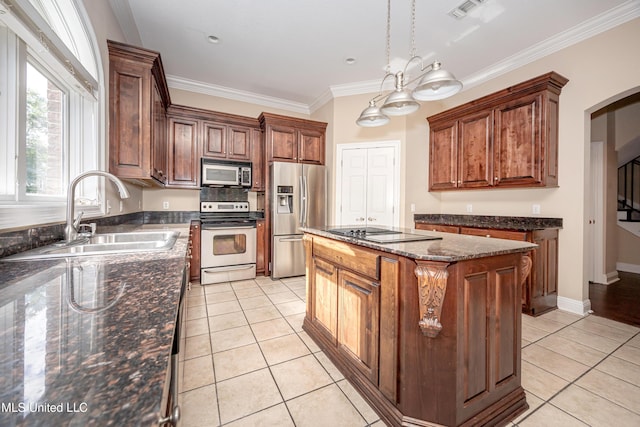 kitchen with appliances with stainless steel finishes, a sink, light tile patterned flooring, a center island, and arched walkways