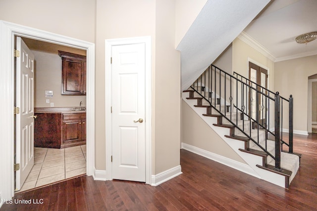 stairway featuring wood finished floors, baseboards, and ornamental molding