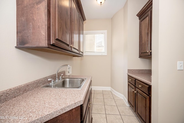 laundry area with cabinet space, baseboards, light tile patterned floors, and washer hookup