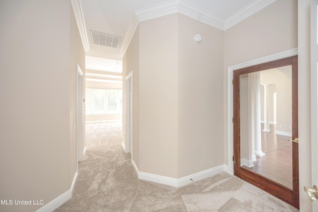 hall with carpet, baseboards, and crown molding