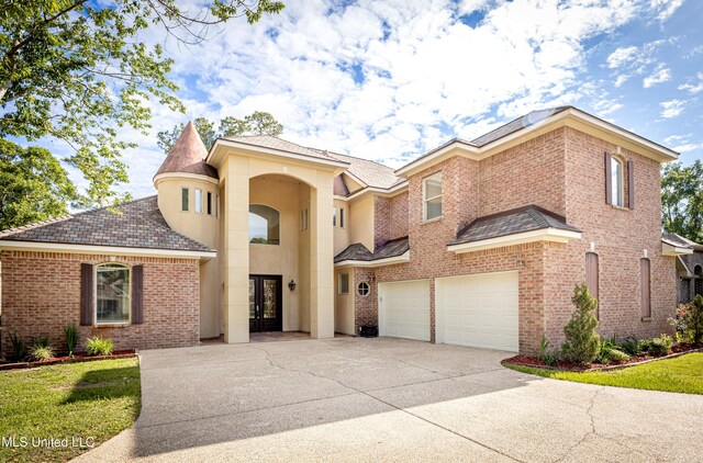 view of front of home featuring concrete driveway, french doors, roof with shingles, and brick siding