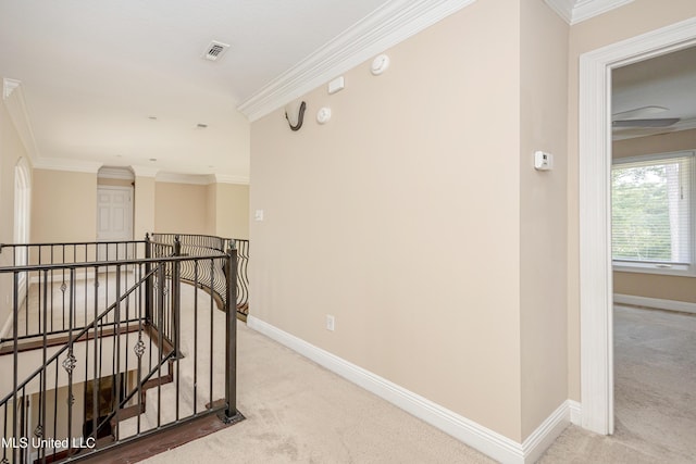 hall featuring carpet flooring, an upstairs landing, baseboards, and crown molding