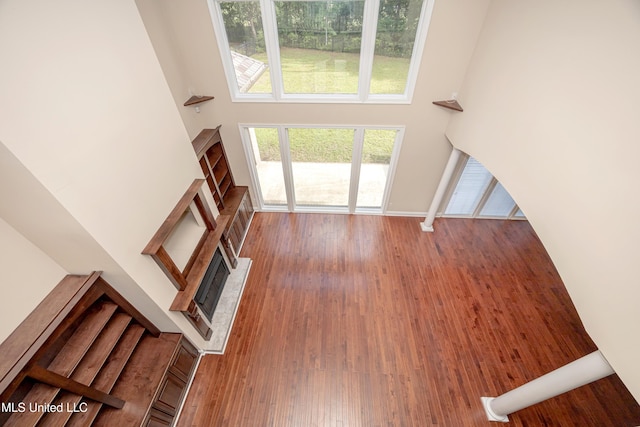 unfurnished living room featuring a towering ceiling and wood finished floors