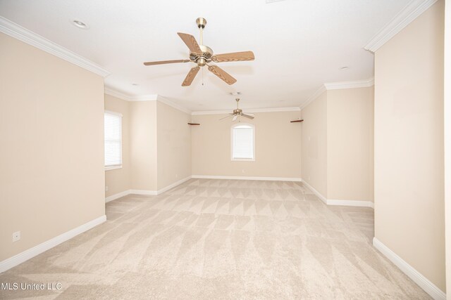 spare room featuring plenty of natural light, light colored carpet, a ceiling fan, ornamental molding, and baseboards