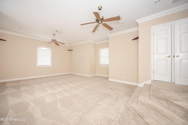 spare room featuring a ceiling fan, light colored carpet, ornamental molding, and baseboards