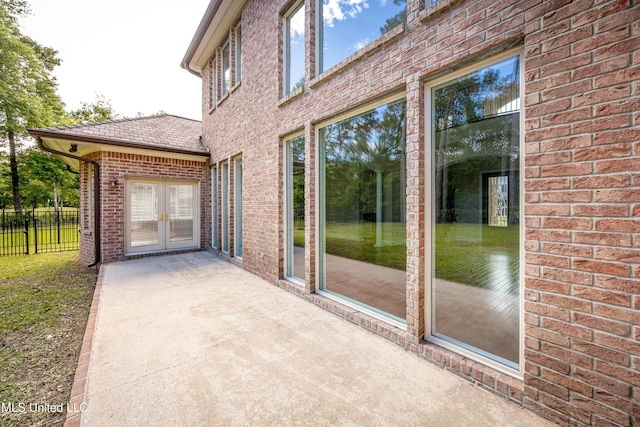 view of patio featuring french doors and fence
