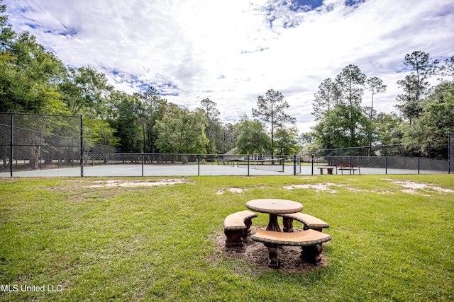 view of home's community with a tennis court