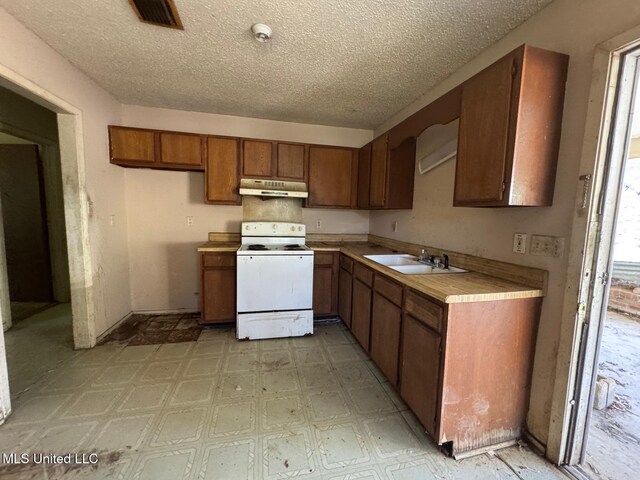 908 Wabash Ave, Vicksburg, MS 39183 - kitchen with electric range, a sink, light countertops, under cabinet range hood, and brown cabinets