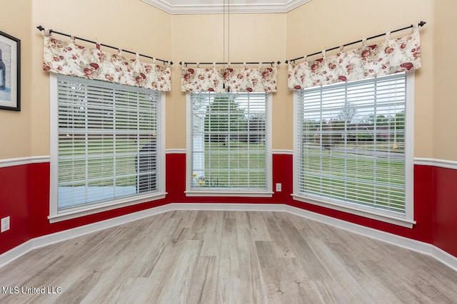 empty room featuring crown molding and light wood-type flooring