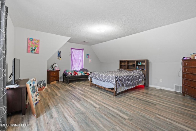 8992 Gavin Dr, Olive Branch, MS 38654 - bedroom with wood finished floors, lofted ceiling, a textured ceiling, and baseboards