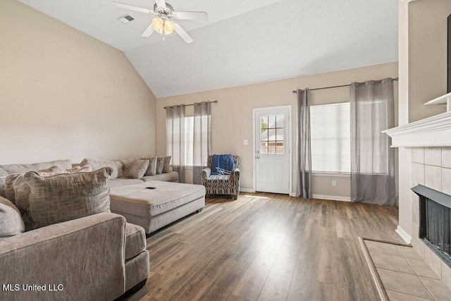 8992 Gavin Dr, Olive Branch, MS 38654 - living area with a tile fireplace, wood finished floors, ceiling fan, lofted ceiling, and baseboards