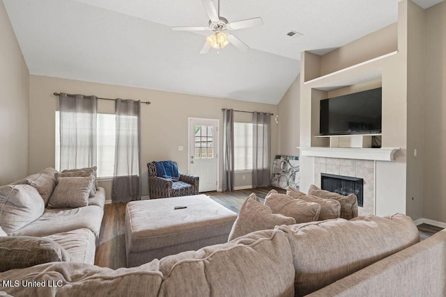 8992 Gavin Dr, Olive Branch, MS 38654 - living area featuring wood finished floors, ceiling fan, a tiled fireplace, lofted ceiling, and baseboards