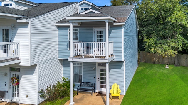 view of front of house featuring a patio area, a balcony, and a front lawn