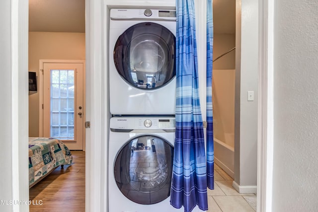 laundry area featuring light wood-type flooring and stacked washing maching and dryer