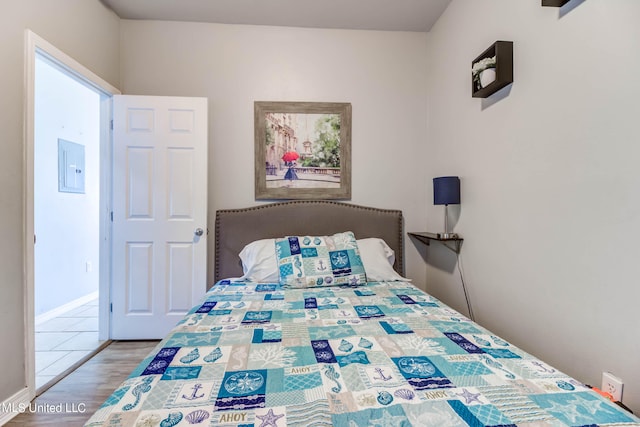 bedroom with electric panel and light wood-type flooring