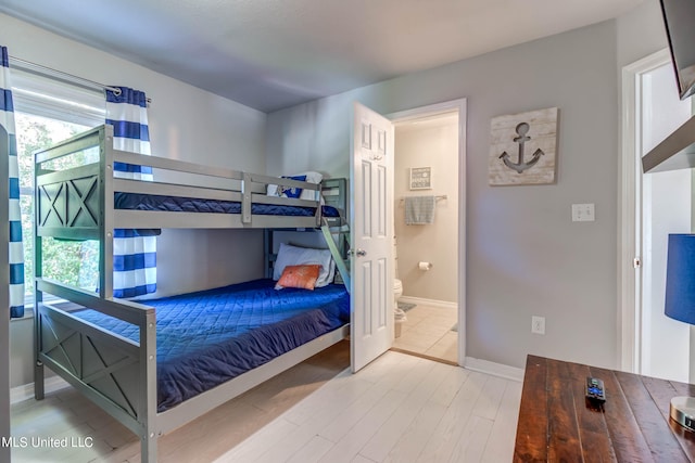 bedroom featuring hardwood / wood-style floors and ensuite bathroom