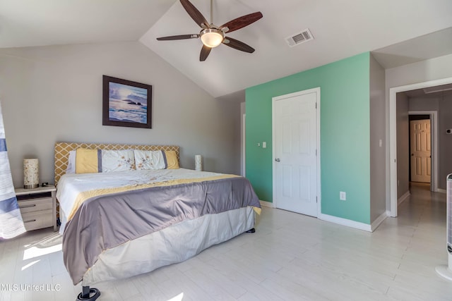 bedroom with ceiling fan, vaulted ceiling, and light wood-type flooring