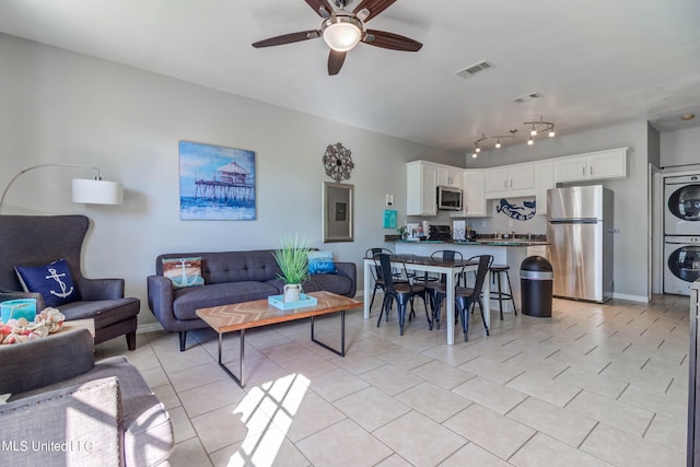 living room with ceiling fan and stacked washer and dryer