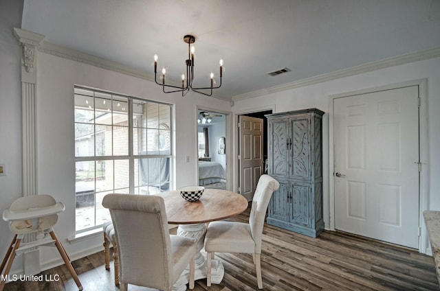 dining room featuring a chandelier, dark hardwood / wood-style flooring, plenty of natural light, and crown molding