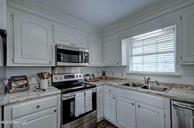 kitchen with stainless steel appliances, white cabinetry, crown molding, and sink