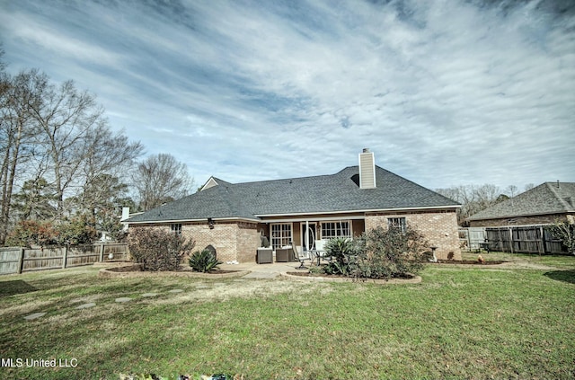 rear view of property with a patio area and a yard