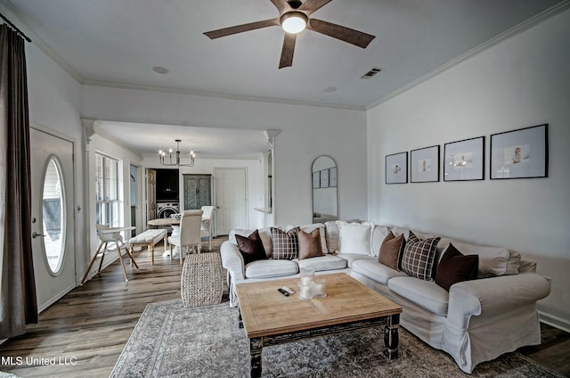 living room featuring crown molding, hardwood / wood-style floors, and ceiling fan with notable chandelier