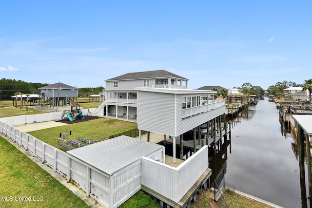 rear view of house featuring a yard and a water view