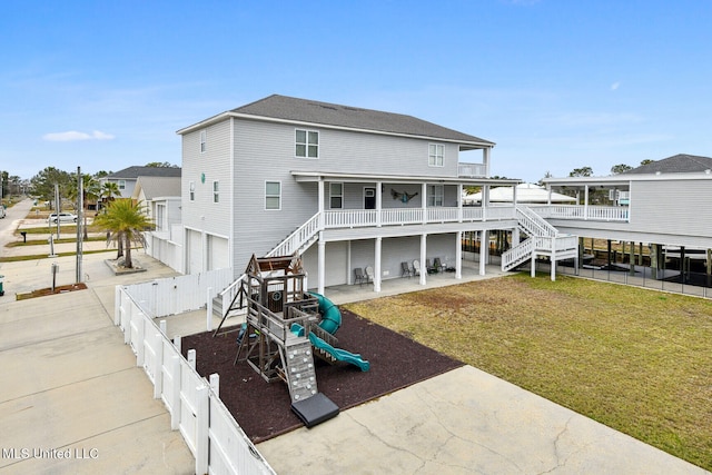 rear view of house featuring a playground and a yard