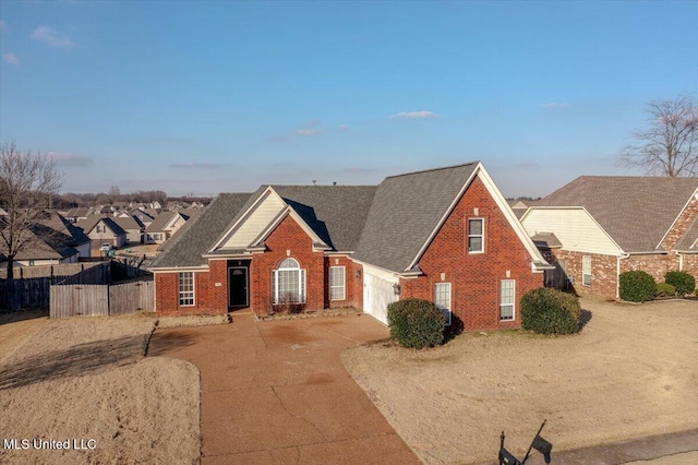 view of front of house featuring brick siding, fence, a garage, a residential view, and driveway