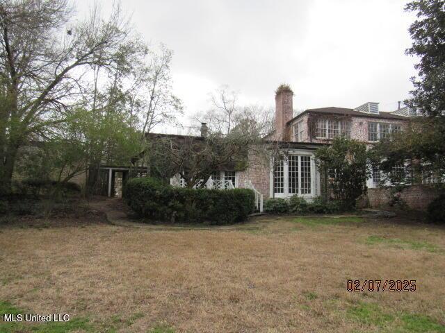 back of house with a lawn