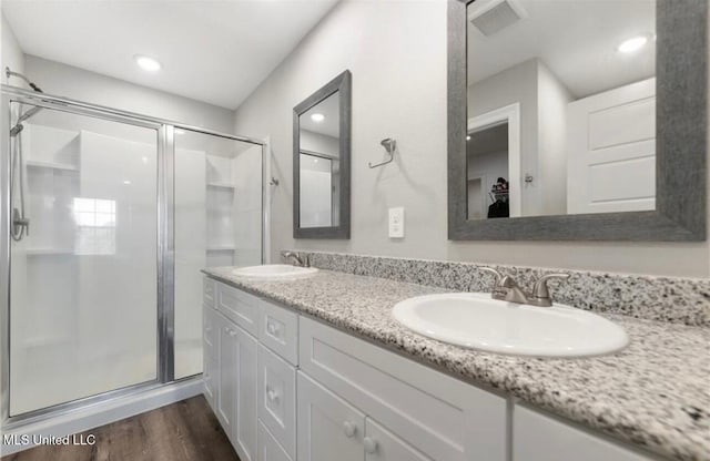 14451 Quail Ridge Dr, Gulfport, MS 39503 - bathroom with a stall shower, wood finished floors, double vanity, and recessed lighting