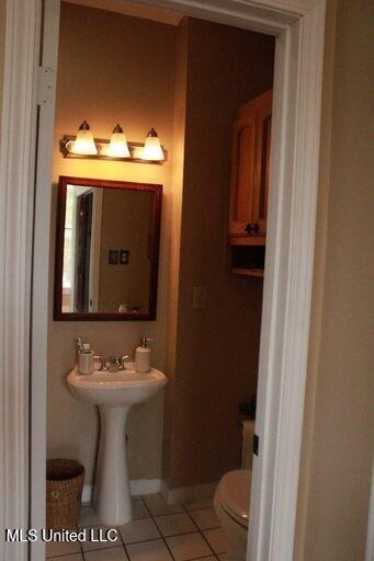 1116 Main St, Natchez, MS 39120 - half bath with tile patterned floors, toilet, and baseboards