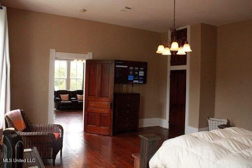 1116 Main St, Natchez, MS 39120 - bedroom with baseboards, an inviting chandelier, and wood finished floors