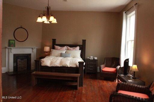 1116 Main St, Natchez, MS 39120 - bedroom with an inviting chandelier and wood finished floors