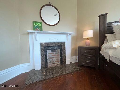 1116 Main St, Natchez, MS 39120 - bedroom with dark wood-type flooring and a fireplace