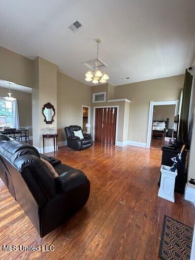 1116 Main St, Natchez, MS 39120 - living area featuring visible vents, baseboards, lofted ceiling, an inviting chandelier, and wood finished floors