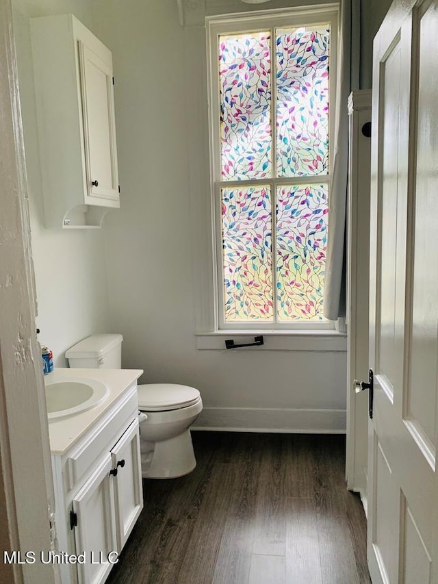 1116 Main St, Natchez, MS 39120 - bathroom featuring vanity, toilet, wood finished floors, and baseboards
