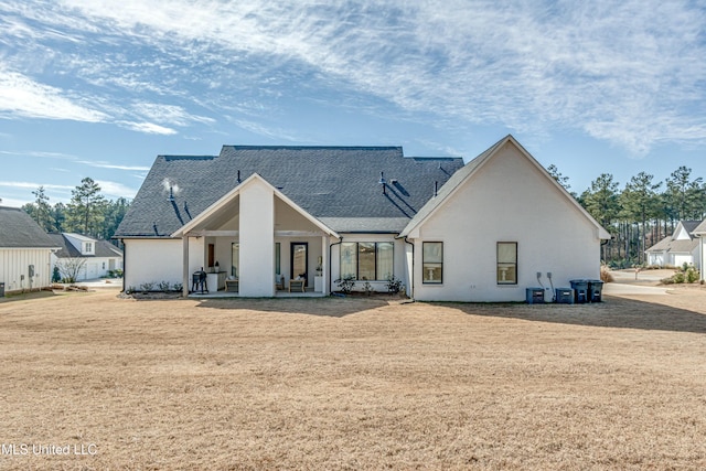 rear view of property featuring central AC, a yard, and a patio area