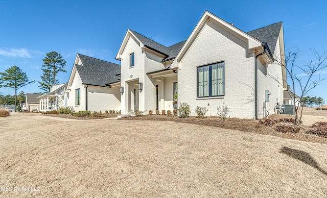 view of front of house featuring cooling unit and a front yard