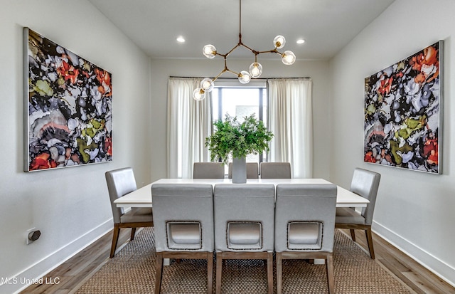 dining room with hardwood / wood-style floors and a chandelier