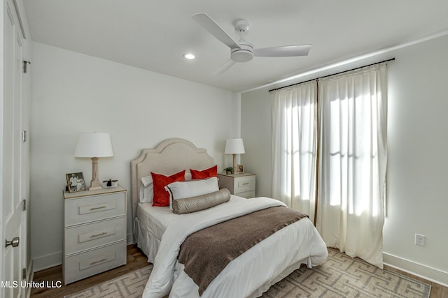 bedroom with multiple windows, ceiling fan, and light wood-type flooring