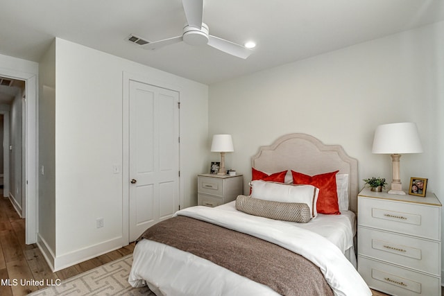 bedroom with light hardwood / wood-style floors, a closet, and ceiling fan