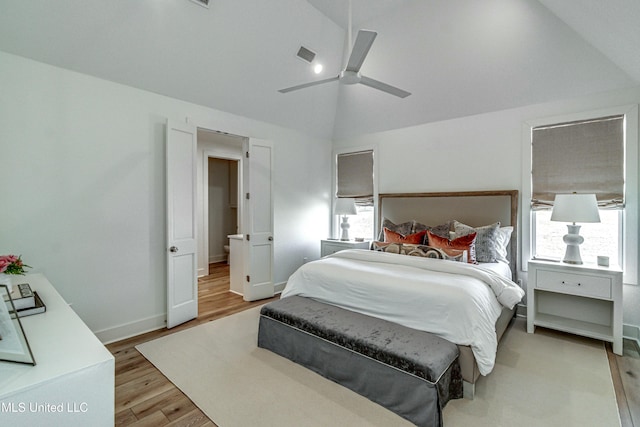 bedroom featuring ceiling fan, lofted ceiling, and light hardwood / wood-style flooring